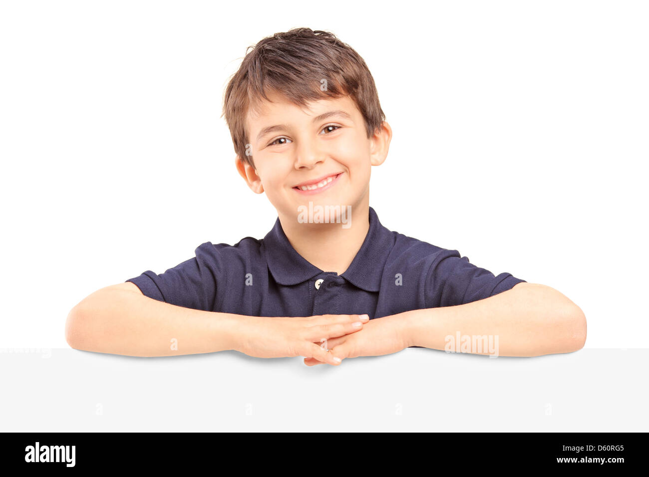 Little smiling boy debout derrière un panneau blanc isolé sur fond blanc Banque D'Images