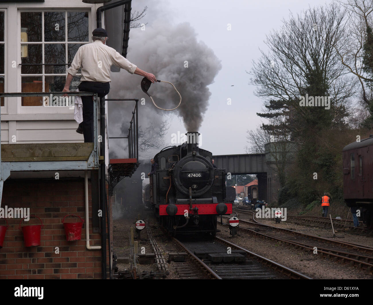 Le signaleur à Sheringham signal fort de l'ouest prépare à céder le droit de passage de jeton le conducteur de loco vapeur 47406 Banque D'Images