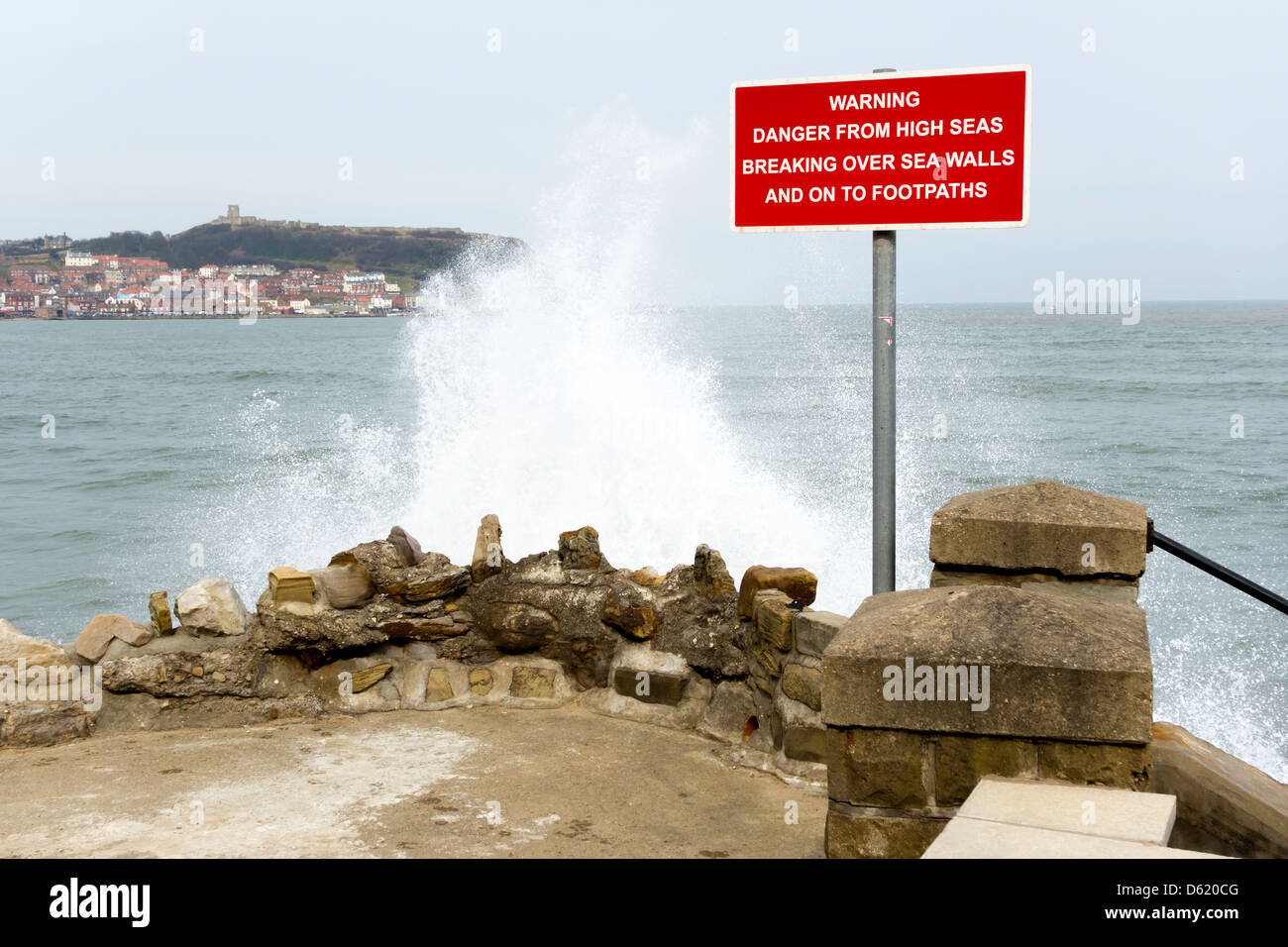 Déferlante derrière un panneau Danger mise en garde contre les risques de rupture en haute mer sur les murs et sur la mer de sentiers Scarborough Banque D'Images