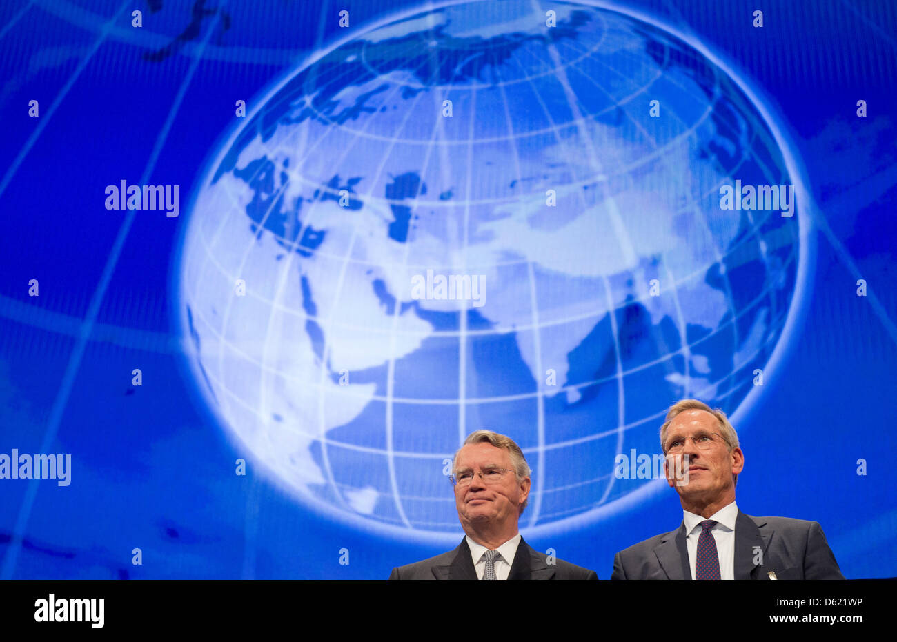 Président du conseil d'Allianz SE Henning Schulte-Noelle (L) et directeur général de se ALiianz Michael Diekmann se tenir en face d'un tableau animé de la planète à l'assemblée générale des actionnaires à la Halle olympique de Munich, Allemagne, 09 mai 2012. Après une assez mauvaise l'année dernière, Allianz peut signaler un bon départ pour 2012. Photo : PETER KNEFFEL Banque D'Images