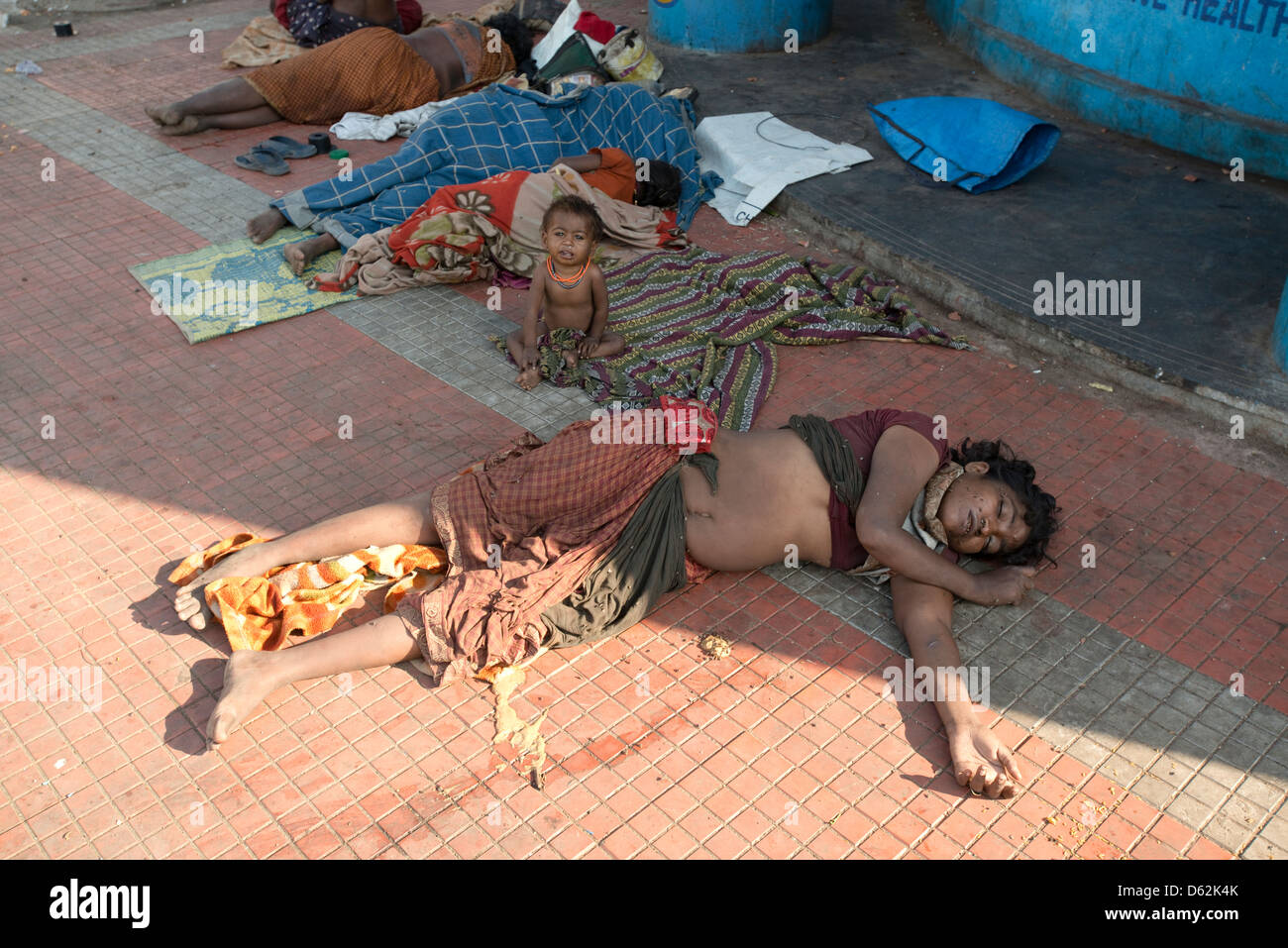 Un enfant pleure misère pendant que sa mère dort dans Chennai, Tamil Nadu, Inde Banque D'Images