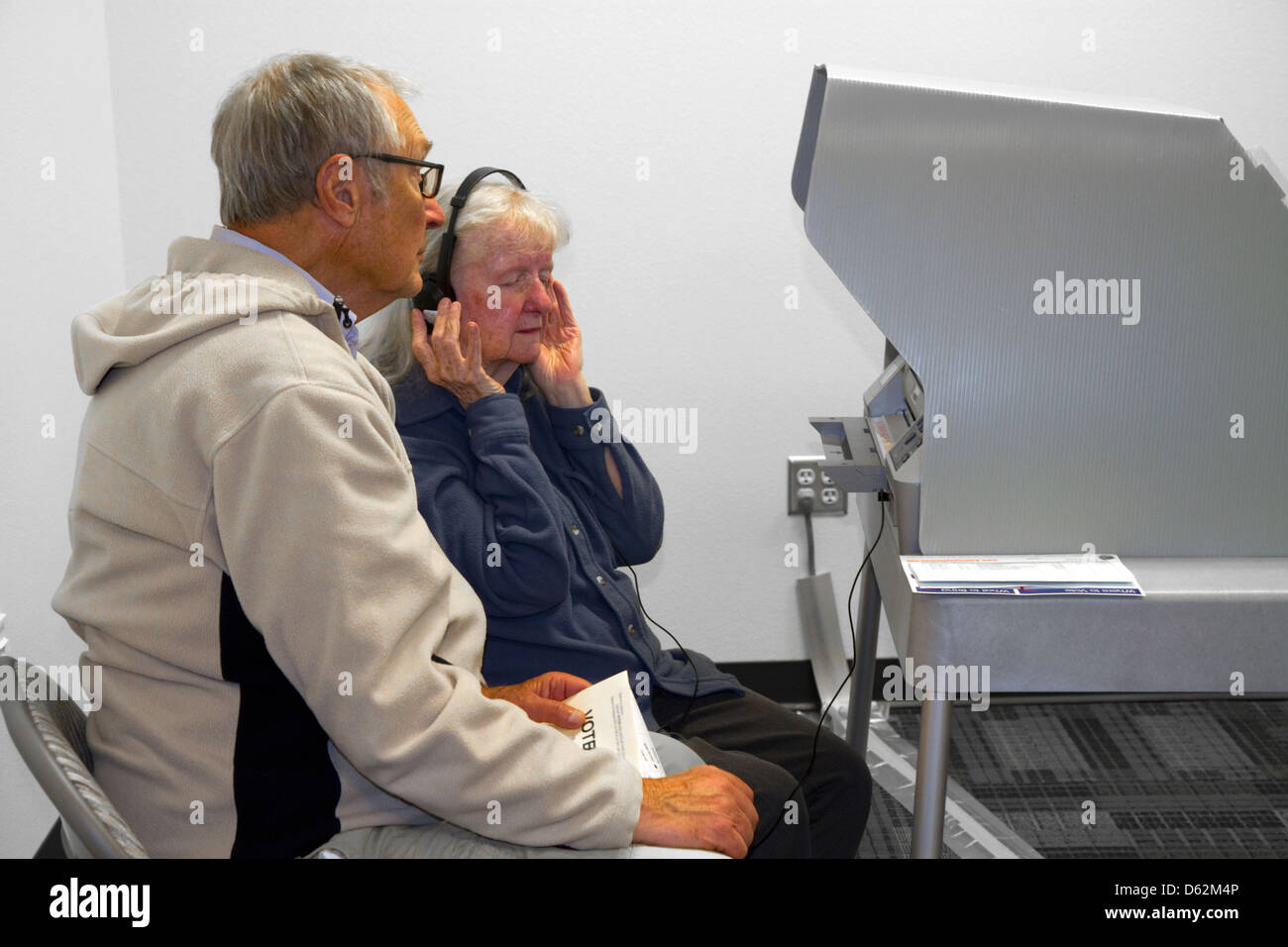 Femme ayant une déficience visuelle à l'aide d'un casque à l'aide de vote à un bureau de scrutin de Boise, Idaho, USA. Banque D'Images