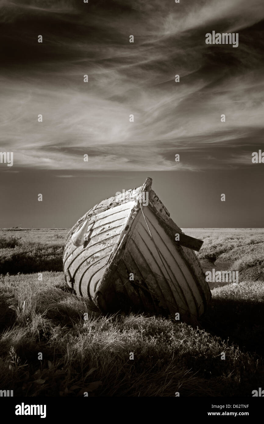 Lonely vieux bateau de pêche en bois sur les marais salés à Burnham Deepdale à Norfolk, UK Banque D'Images