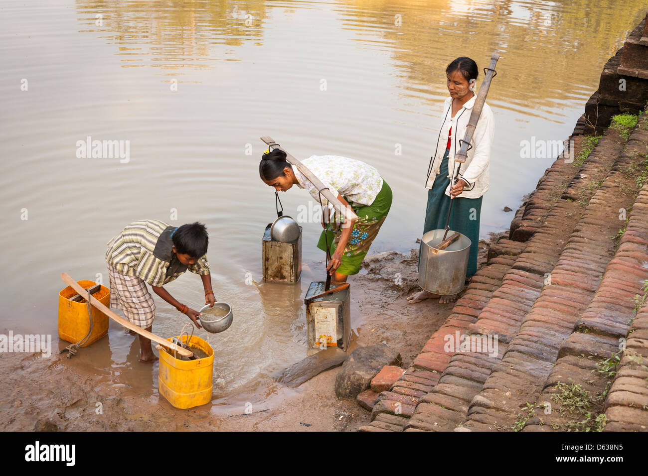 Les villageois d'eau de remplissage contenant de l'eau, Minnanthu, Bagan, Myanmar (Birmanie), Banque D'Images