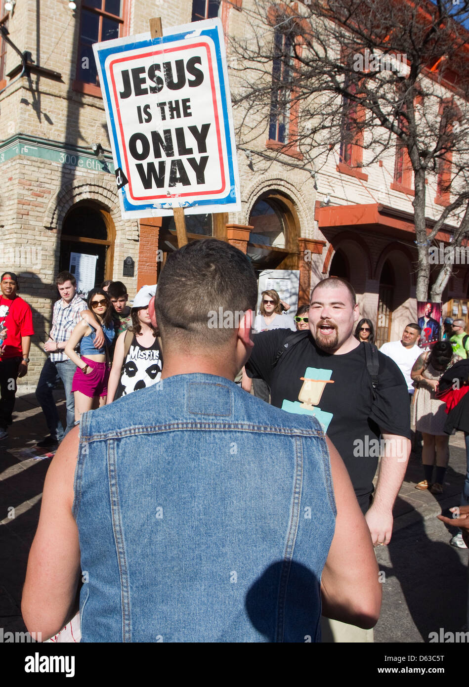 Les jeunes hommes homosexuels hispaniques soutient avec un anti-gay religieux homme de race blanche au cours d'un festival en plein air à Austin, Texas Banque D'Images