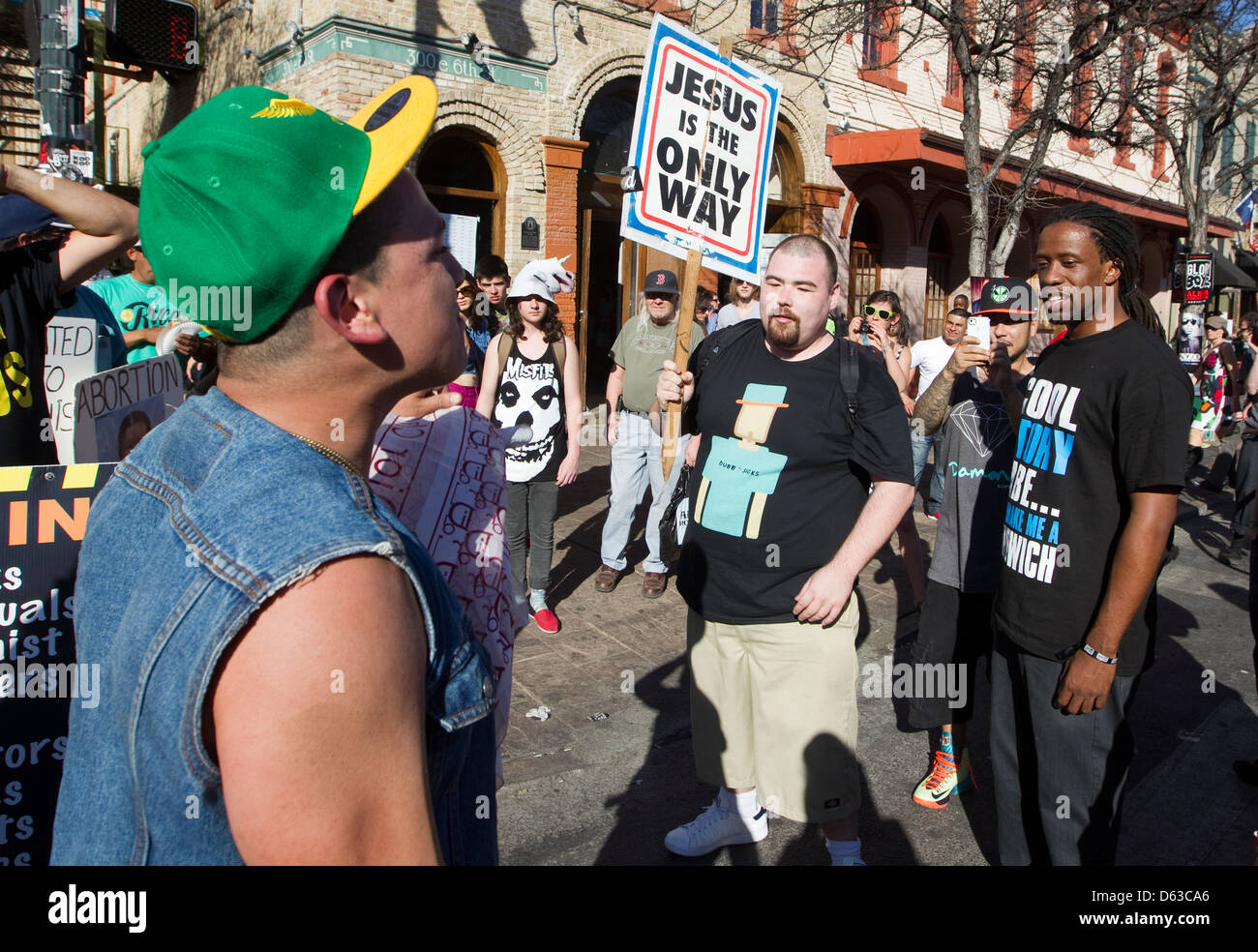 Les jeunes hommes homosexuels hispaniques soutient avec un anti-gay religieux homme de race blanche au cours d'un festival en plein air à Austin, Texas Banque D'Images