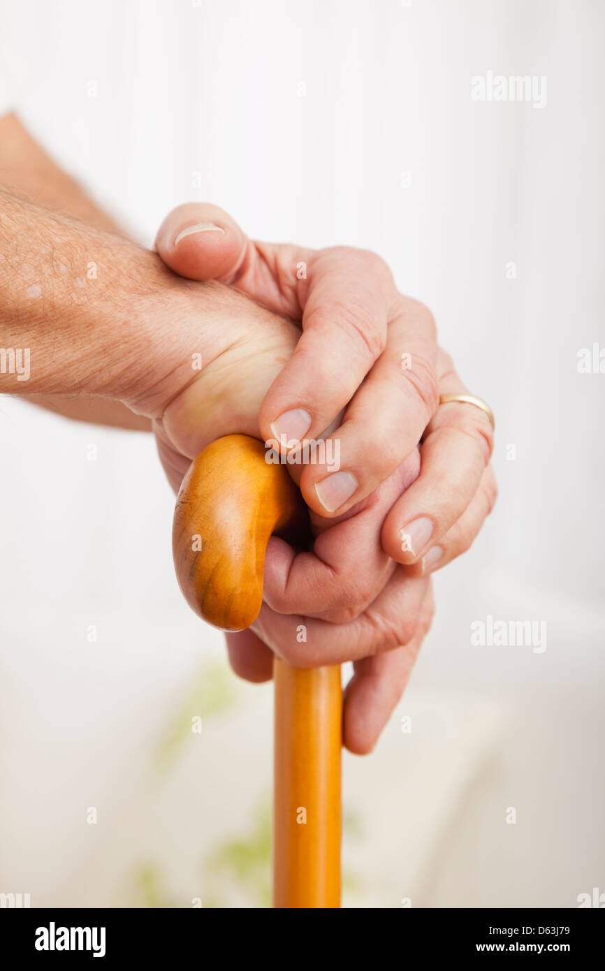 Close up of senior man's hands, appuyé sur la canne à sucre Banque D'Images