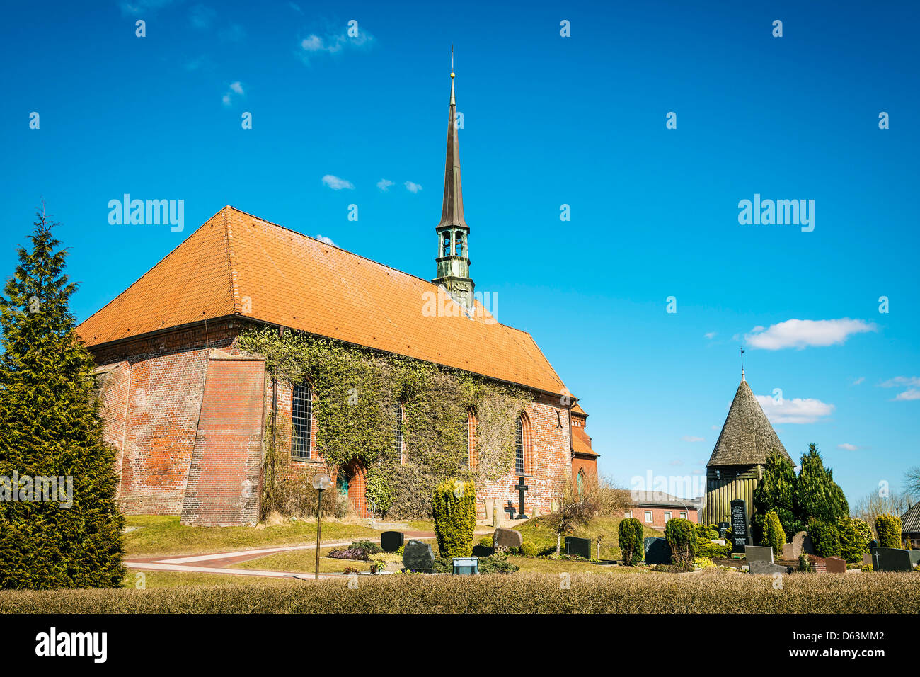 L'église en brique rouge et le cimetière les jours de soleil au printemps dans le village Witzwort, Allemagne Banque D'Images