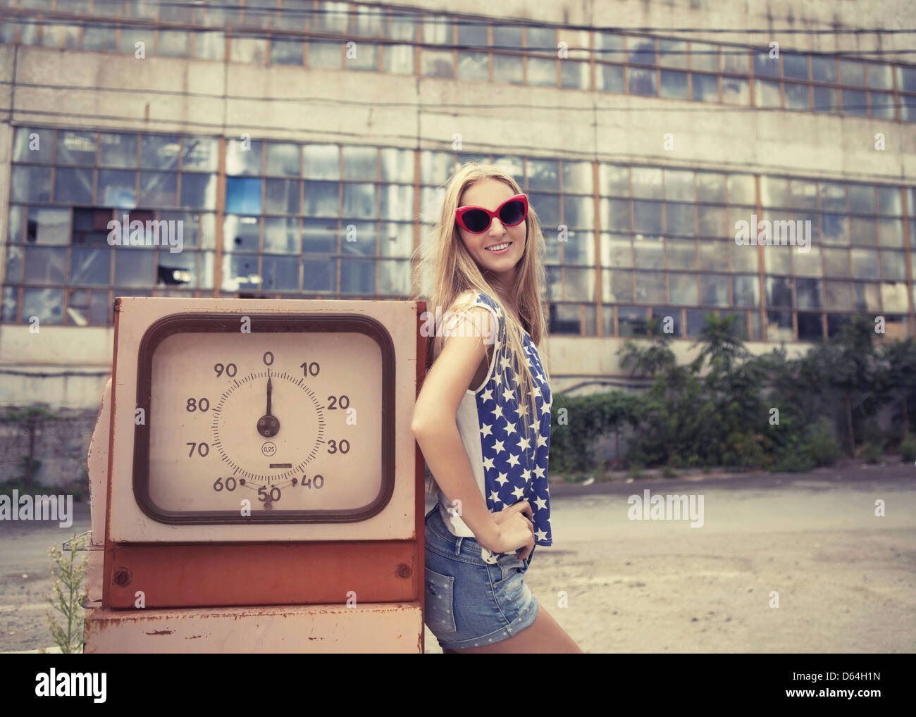 Fille blonde sur station de gaz endommagées Banque D'Images