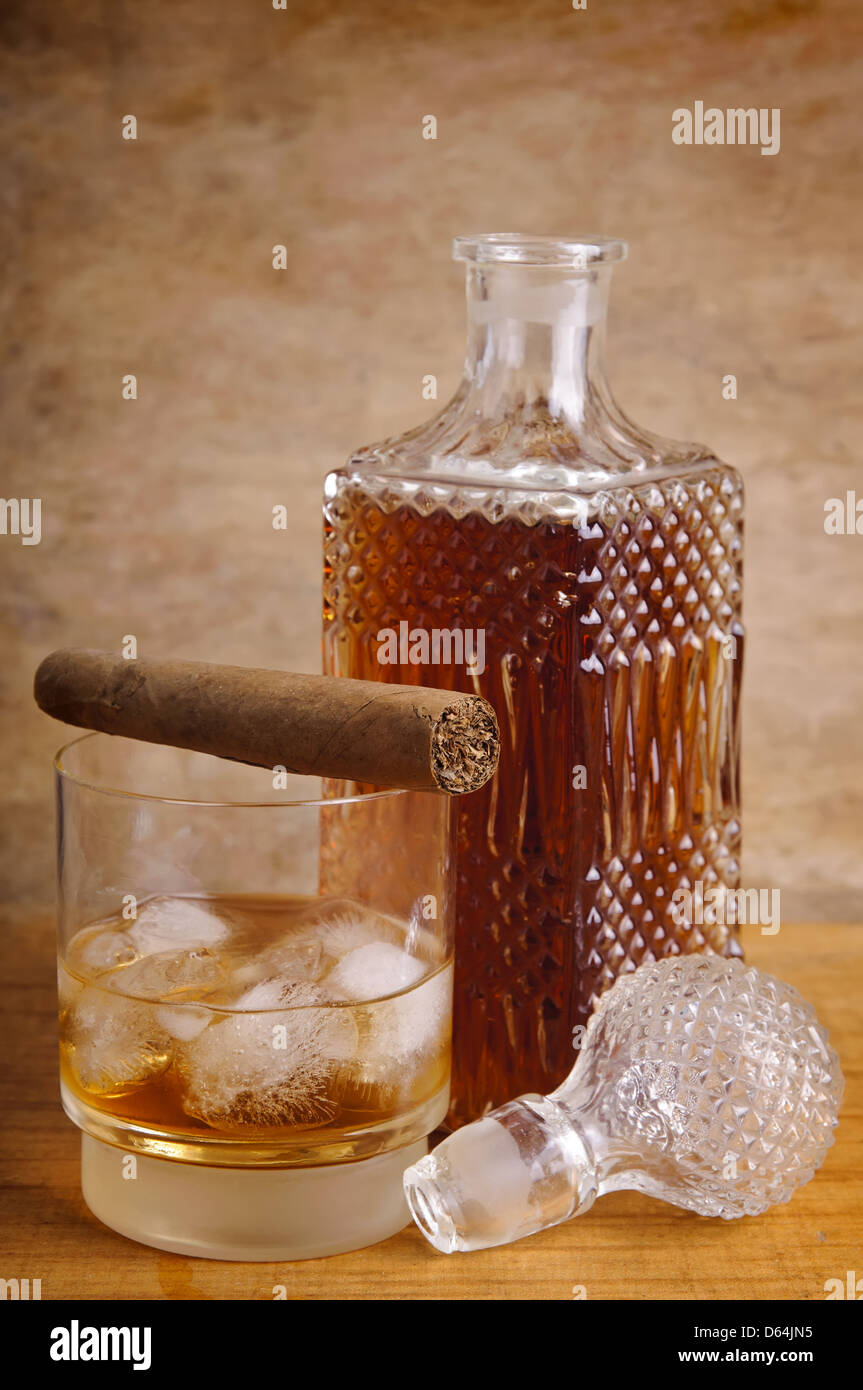 Composition de la vie toujours avec le verre et bouteille de whisky et cigare, sur un arrière-plan vintage en bois Banque D'Images