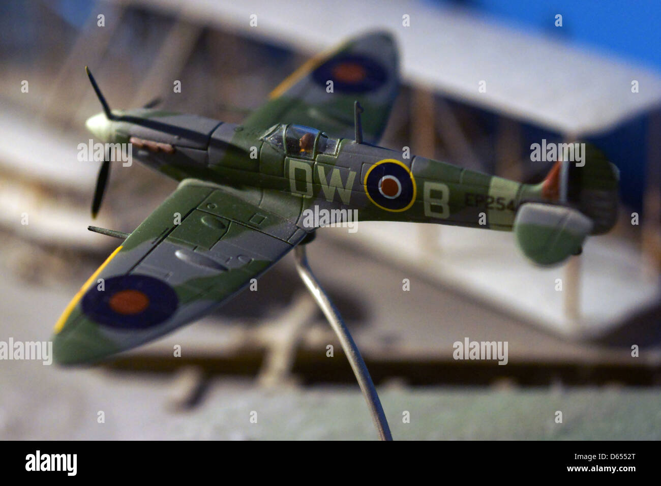 Spitfire flying model plane stand mur bleu poussière Banque D'Images