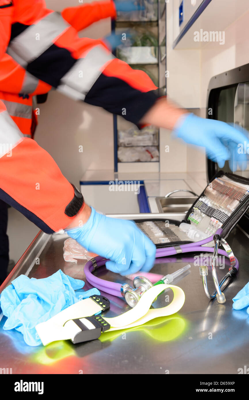 Le personnel paramédical à la hâte avec des équipements médicaux à l'intérieur voiture ambulance Banque D'Images