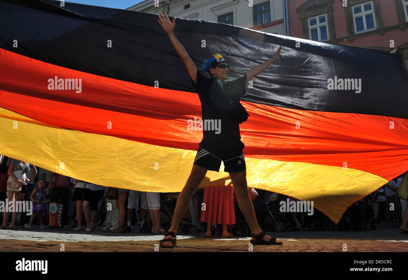 Un ventilateur se trouve en face d'un drapeau allemand avant au centre-ville de Lviv à l'UEFA EURO 2012 groupe B match de foot France contre l'Allemagne à Arena Lviv de Lviv, Ukraine, 17 juin 2012. Photo : Andreas Gebert dpa  + + +(c) afp - Bildfunk + + + Banque D'Images