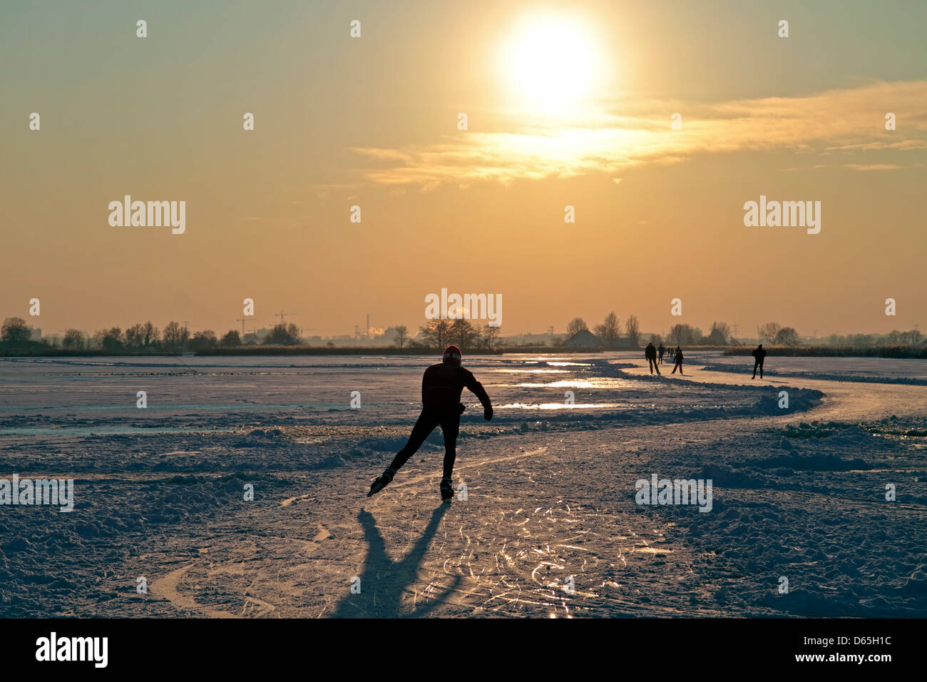 Patin à glace dans la campagne des Pays-Bas au coucher du soleil Banque D'Images