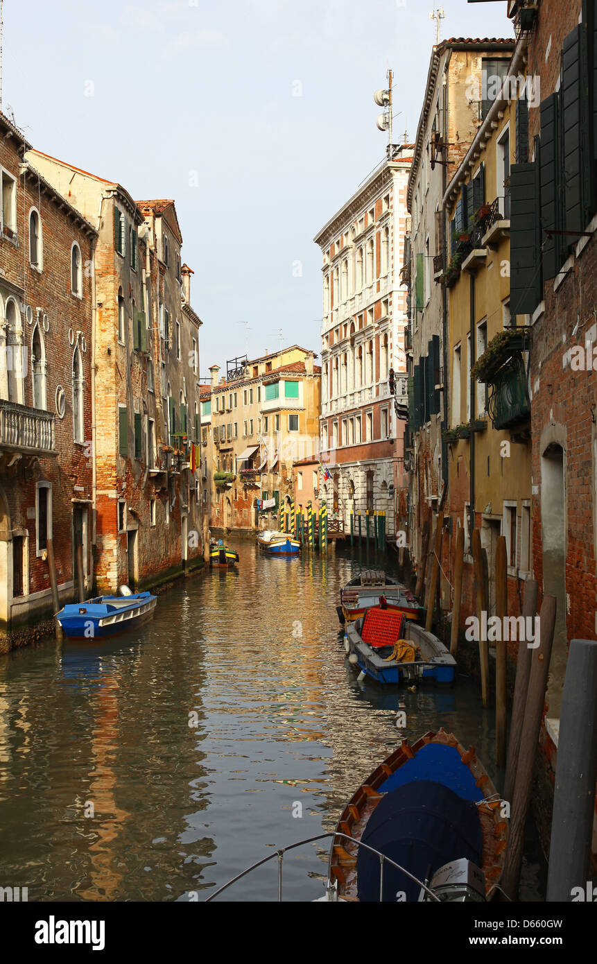 Bateaux dans un petit canal latéral avec des vieux bâtiments de Venise Italie Banque D'Images