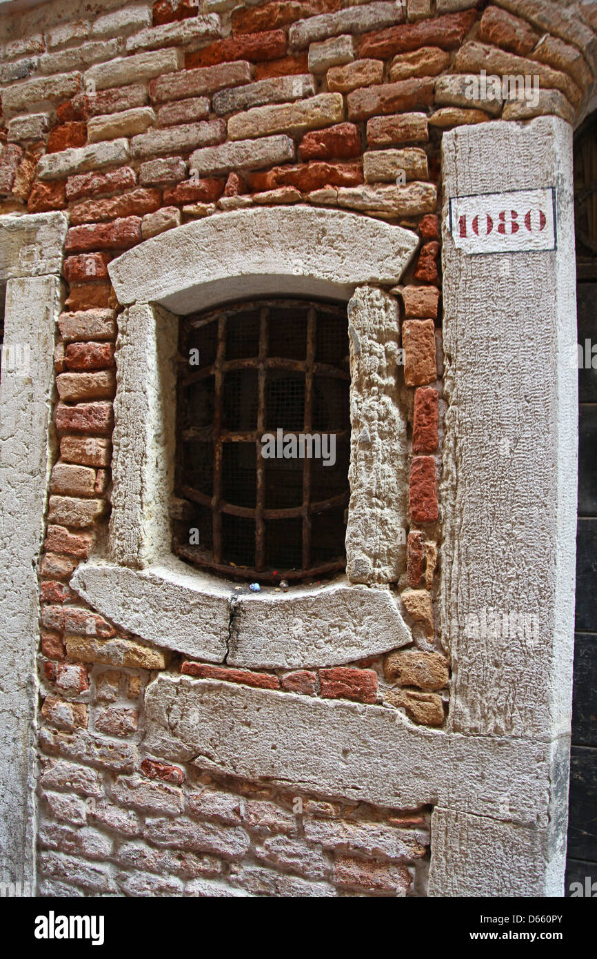 Une ancienne fenêtre dans un mur en brique Venise Italie Banque D'Images