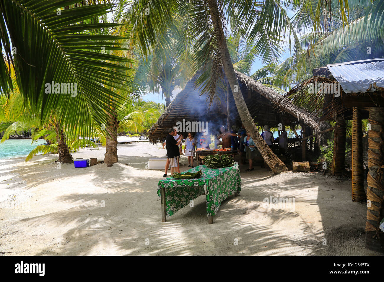 Les touristes appréciant un déjeuner barbecue sur l'une des îles de l'anneau extérieur autour de Bora Bora. Banque D'Images