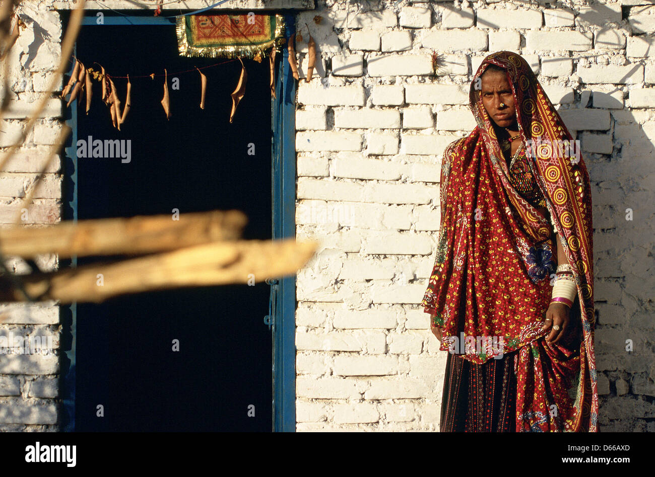 Femme indienne habillé traditionnellement en face de sa maison. Elle appartient à la caste Rebari ( Inde) Banque D'Images