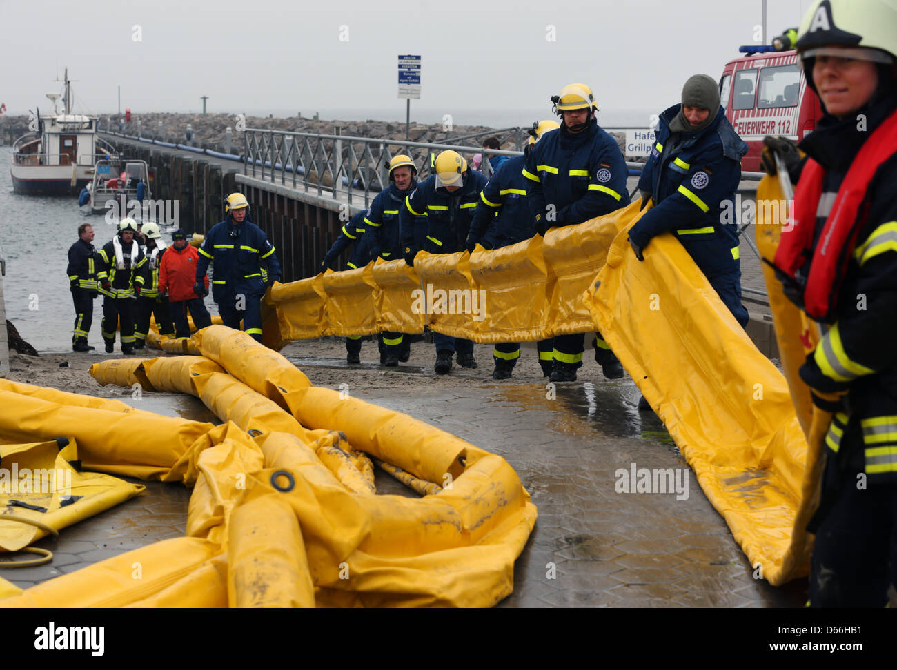 Les membres de la brigade du feu et de l'Agence de secours technique (THW) pratique comment retirer un déversement de pétrole dans le port de plaisance à Kühlungsborn sur la mer Baltique, Allemagne, 13 avril 2013. Plus de 100 action force ont pris part à l'exercice de grande envergure. Photo : Bernd Wuestneck Banque D'Images