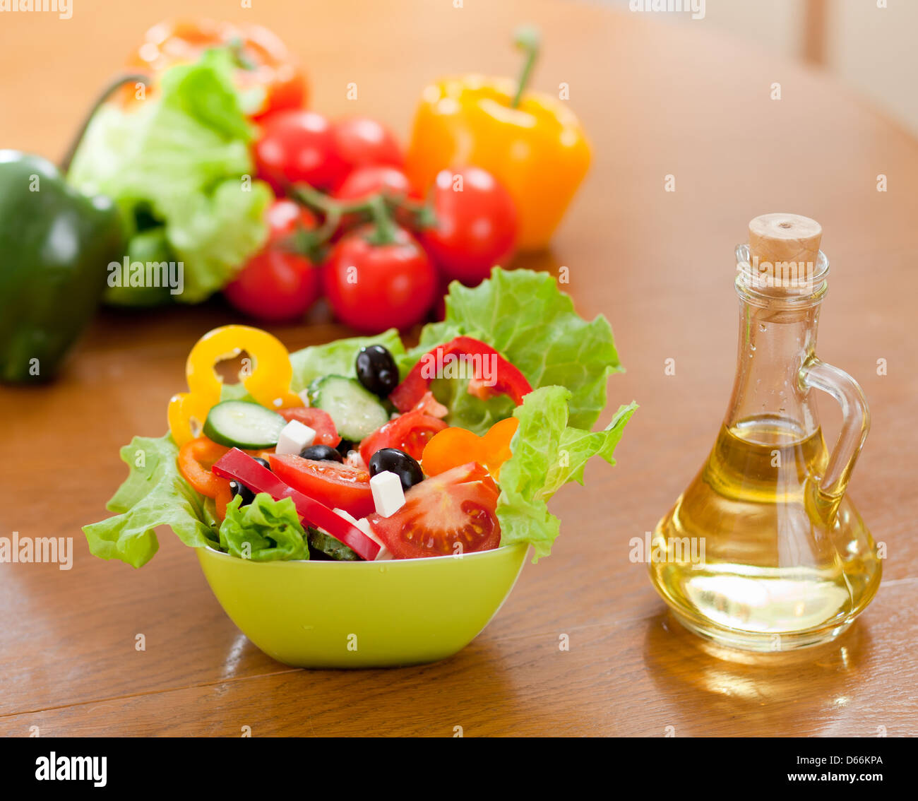 Salade de légumes grecque et une bouteille avec de l'huile de tournesol sur table en bois Banque D'Images