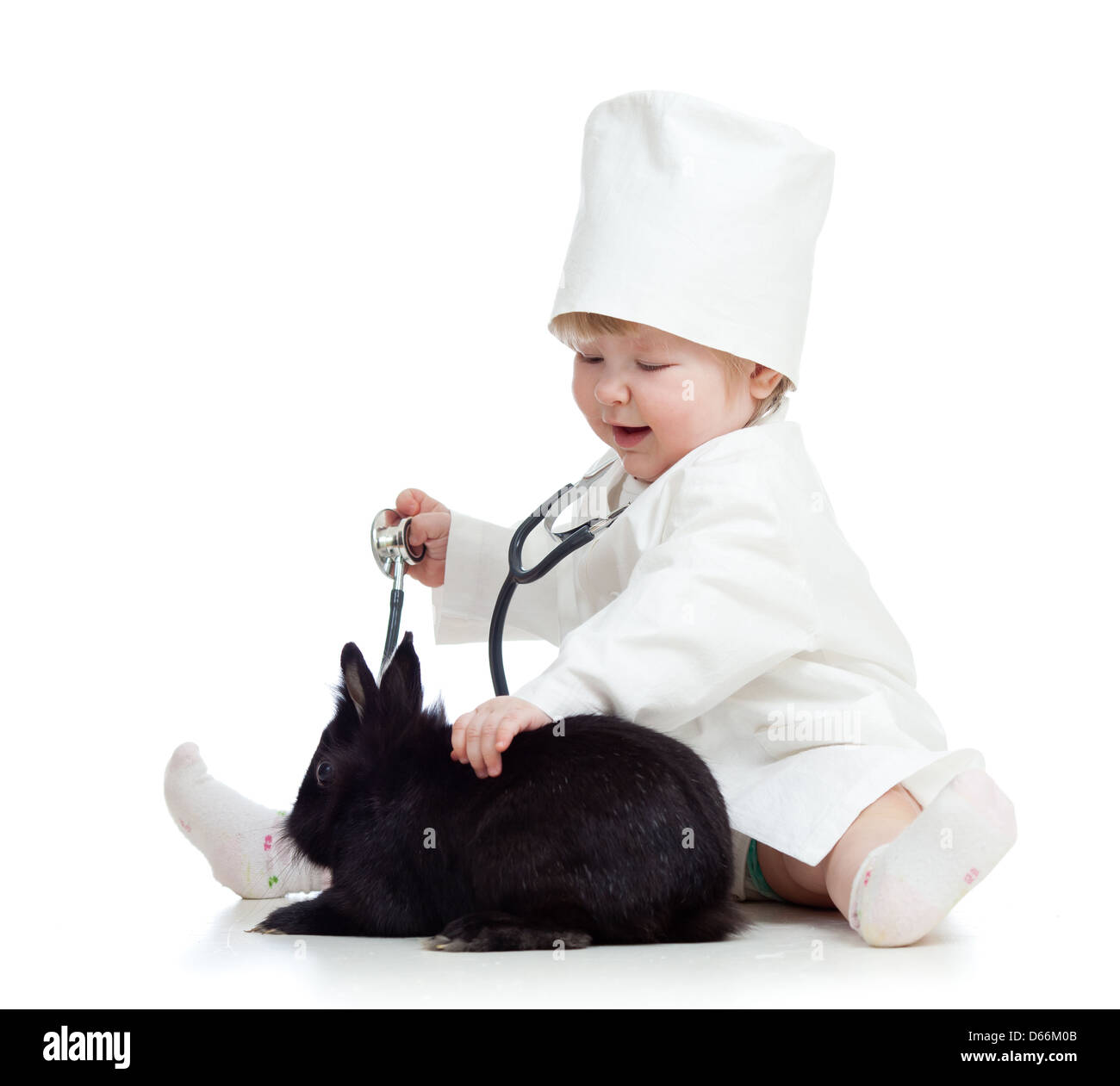 Adorable enfant avec des vêtements de médecin. Girl joue avec le pet bunny Banque D'Images