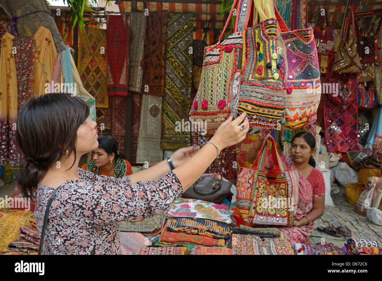 Une jeune fille d'admirer un sac devrait lors d'un marché de rue à New Delhi, Inde Banque D'Images