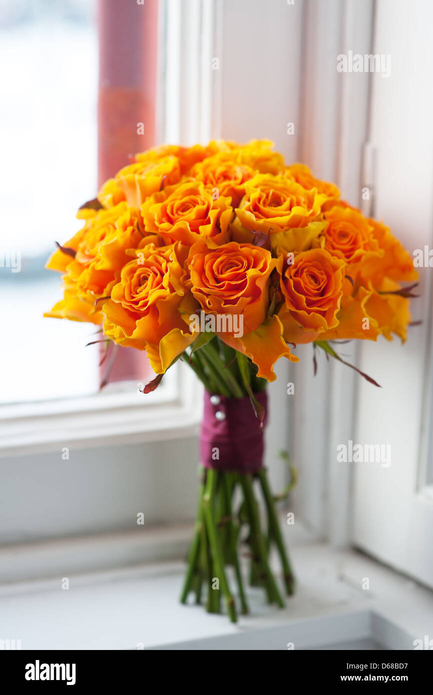 Mariage bouquet de roses orange sur un rebord de fenêtre par un Banque D'Images