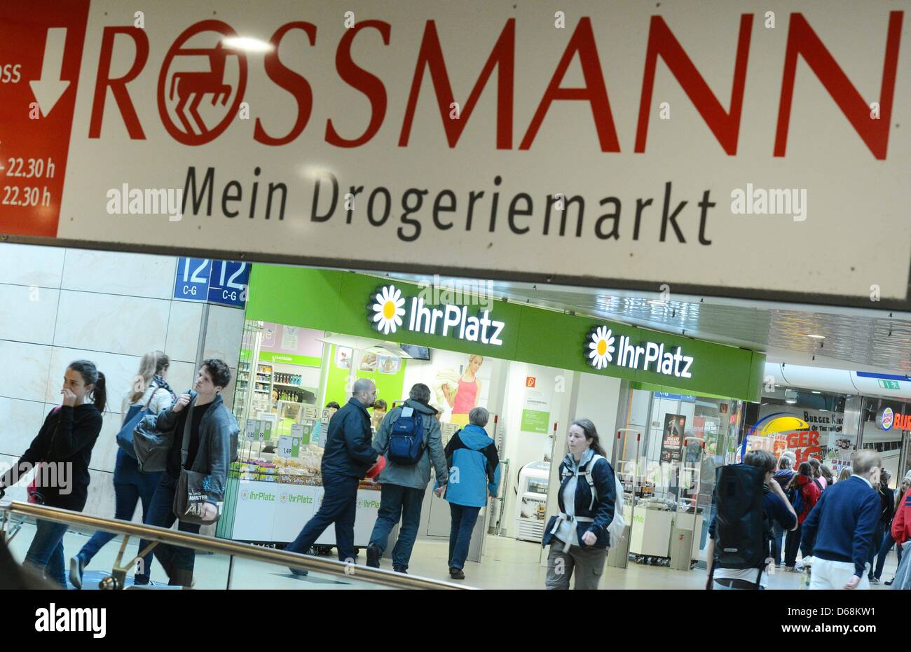 Les gens passent devant un magasin de chaîne de IhrPlatz et une publicité pour la chaîne de pharmacies Rossmann à Hanovre, Allemagne, 18 juillet 2012. Chaîne Rossmann envisage de prendre plus de 120 magasins de Schlecker insolvable. IhrPlatz subsidiaires L'Office fédéral des ententes en ce moment reviews une telle proposition. Photo : JULIAN STRATENSCHULTE Banque D'Images