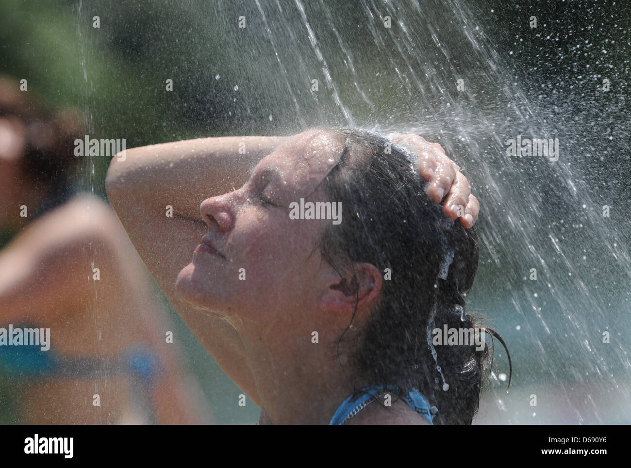 Selina bénéficie d'une douche froide à l'Gifiz lake zone de baignade publique à Offenburg, Allemagne, 26 juillet 2012. Les gens recherchent de rafraîchissement sur les lacs et les piscines à des températures supérieures à 30 degrés Celsius. Photo : PATRICK SEEGER Banque D'Images