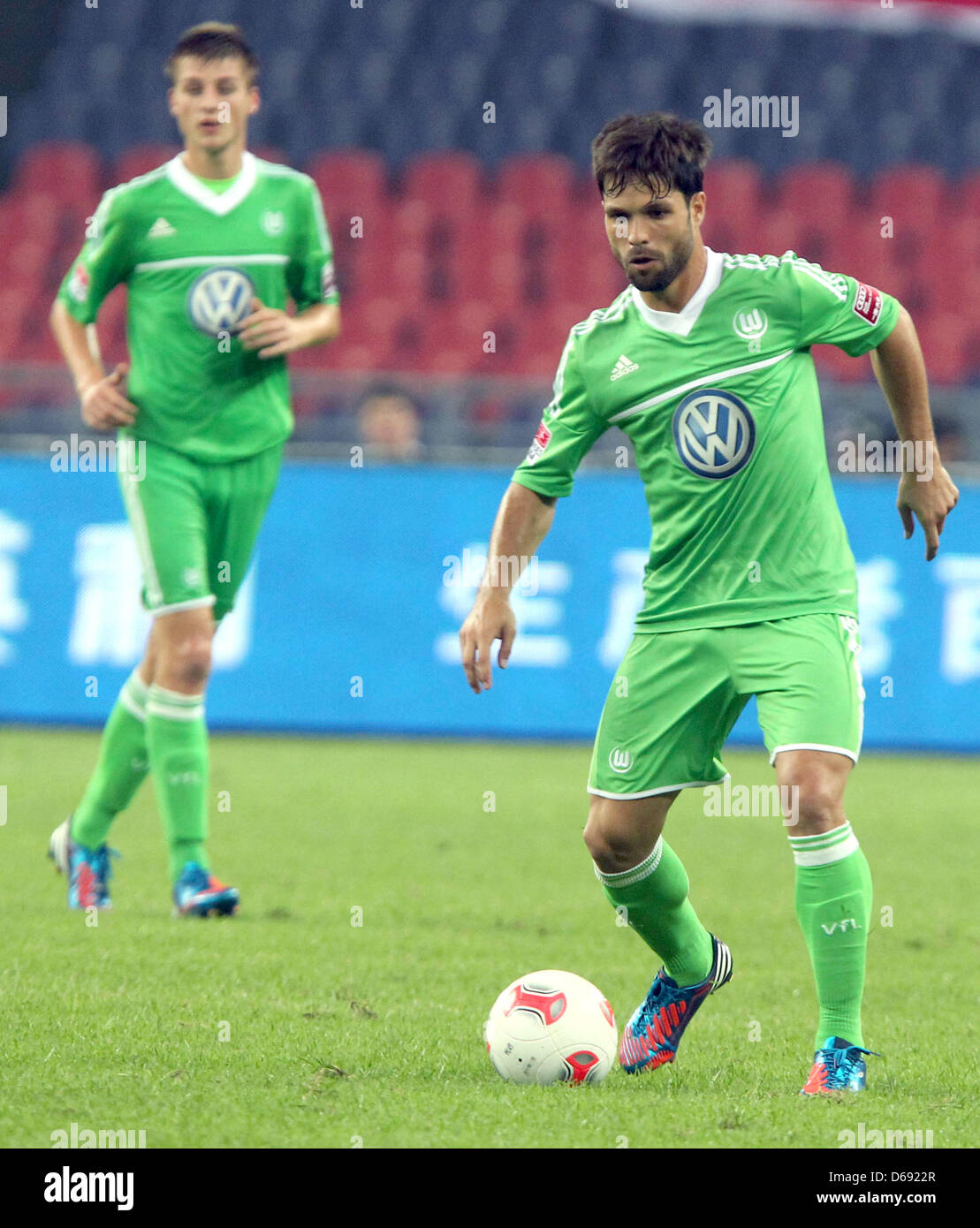 De Wolfsburg Diego (C) passe le ballon pendant le test match de la Bundesliga allemande clubs de football du VfL Wolfsburg vs FC Bayern Munich à Guangzhou, Chine, le 26 juillet 2012. Photo : Roland Hermstein Banque D'Images