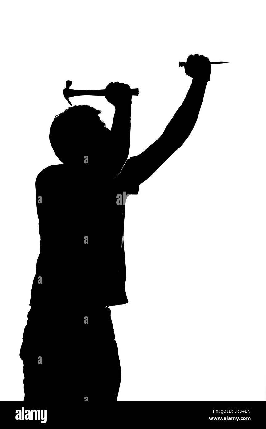 Silhouette d'un homme avec un marteau et un clou. Banque D'Images