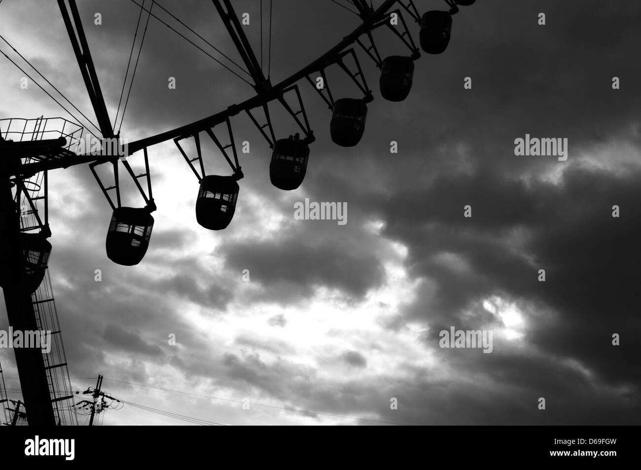 Une grande roue abandonnée dans la préfecture de Shiga, au Japon, près de la tour Biwako. La scène capture une structure d'amusement en décomposition sur fond de ciel couvert, offrant un aperçu dans une zone de loisirs oubliée. Banque D'Images