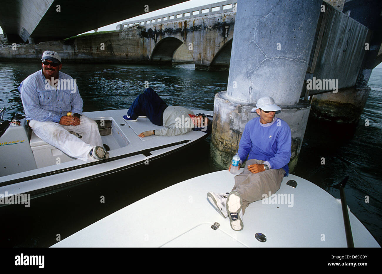 Tarpon des guides de pêche et les clients de manger le déjeuner pendant une tempête de pluie sous le Seven Mile Bridge à Marathon dans les Florida Keys Banque D'Images