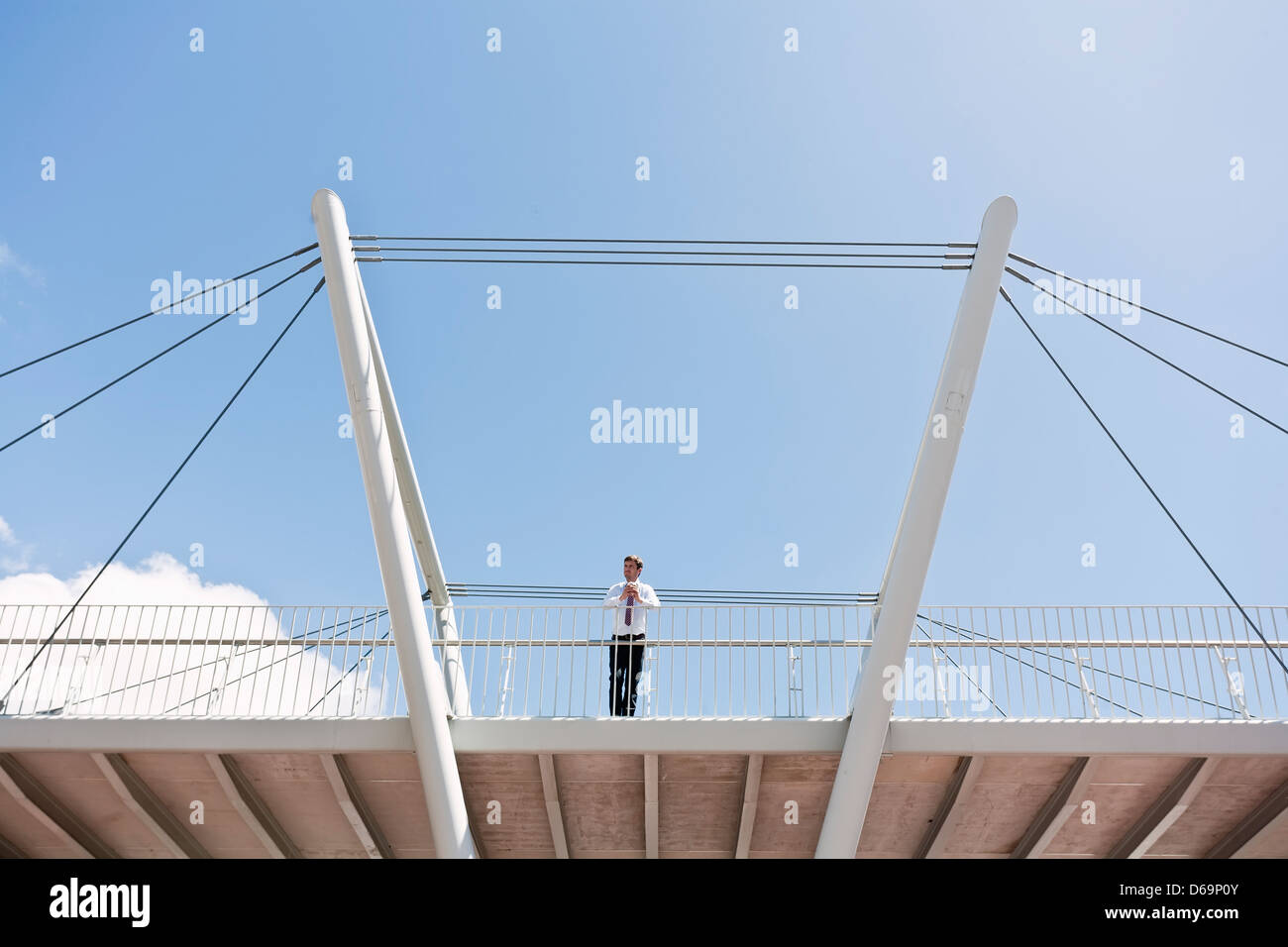 Businessman standing on urban bridge Banque D'Images