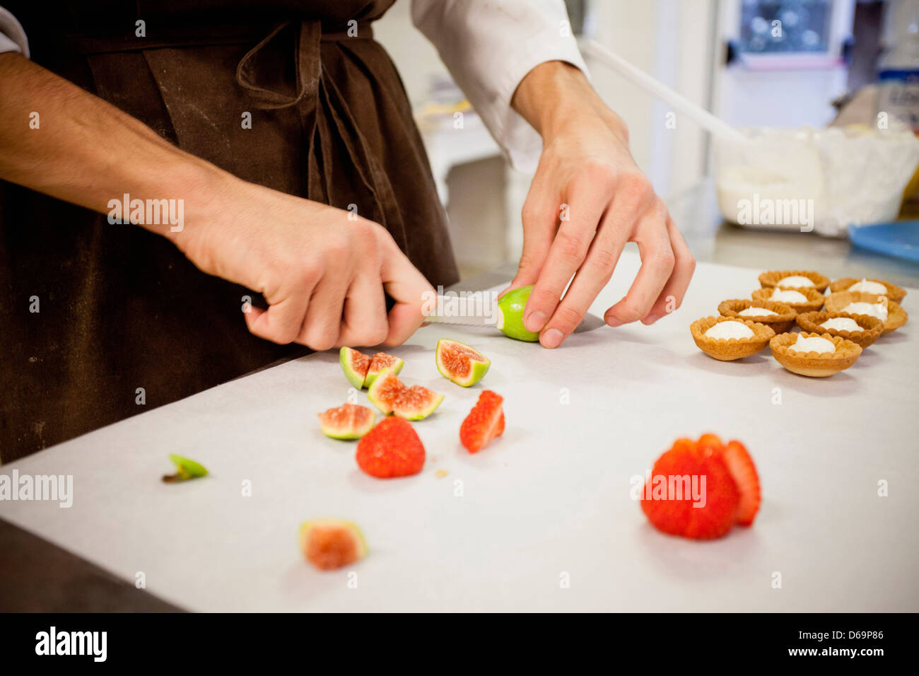 Baker slicing fruit en cuisine Banque D'Images
