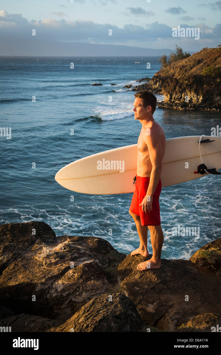 Surfer carrying board on beach Banque D'Images Surfer carrying board on beach Banque D'Images