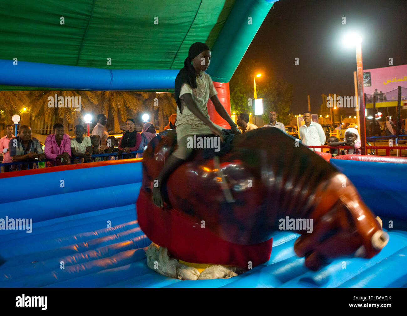 Girl Riding A Bull dans une fête foraine, Port Soudan, Soudan Banque D'Images