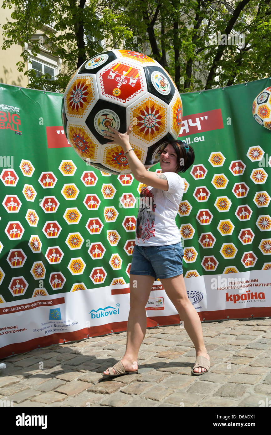 Lviv, Ukraine, une jeune femme n'est possible de prendre des photos en face de la publicité pour le football amateur Banque D'Images