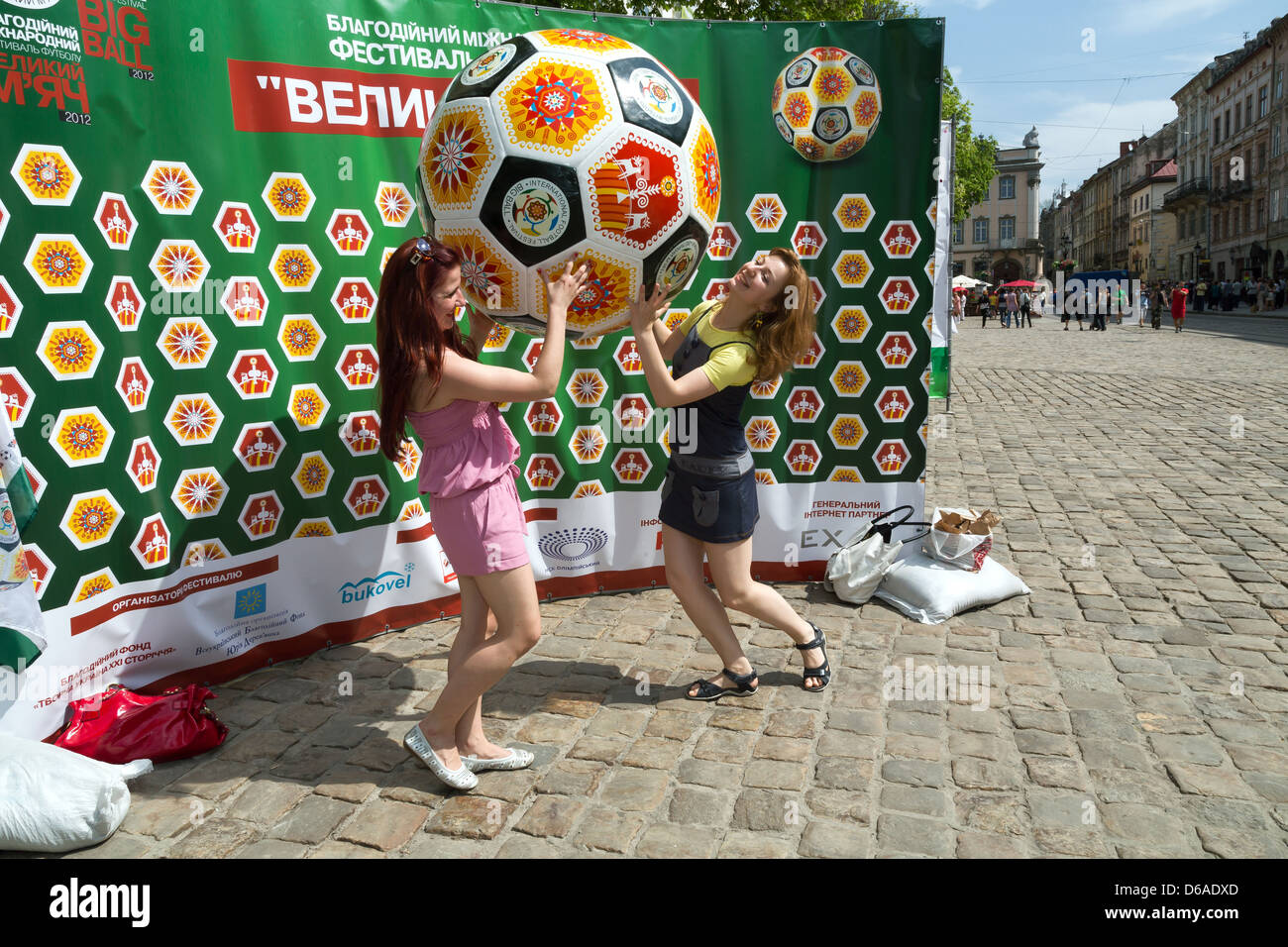 Lviv, Ukraine, les jeunes femmes ont leurs photos prises en face de la publicité pour le football amateur Banque D'Images