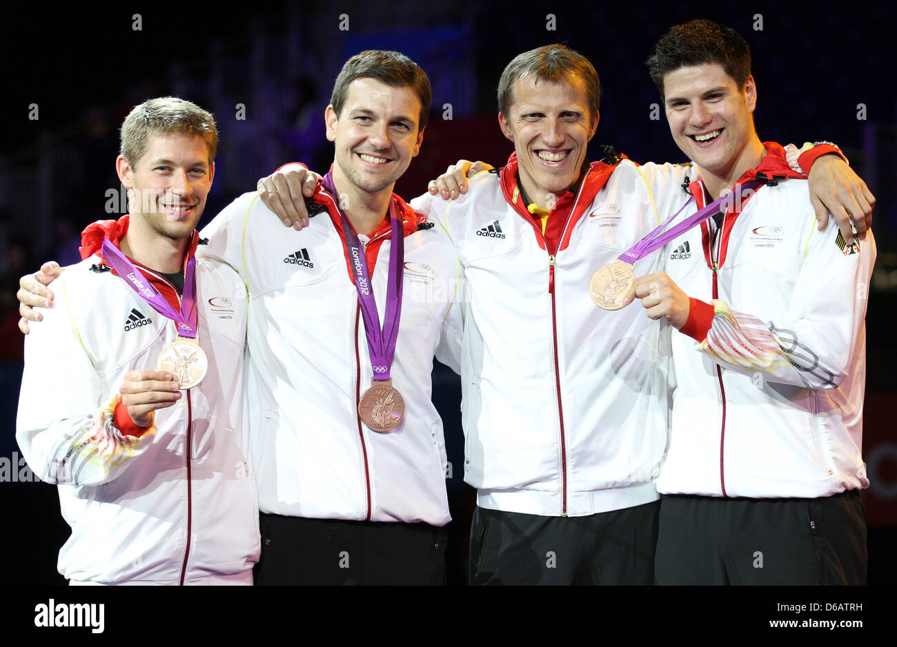 Allemagne (L-R) Bastian Steger, Timo Boll, entraîneur Joerg Rosskopf et Dimitrij Ovtcharov célébrer leurs médailles de bronze lors de la cérémonie de remise des médailles pour l'équipe masculine de tennis de table dans ExCeL à l'arène pour les Jeux Olympiques de 2012 à Londres, Londres, Grande-Bretagne, 08 août 2012. Photo : Friso Gentsch dpa  + + +(c) afp - Bildfunk + + + Banque D'Images