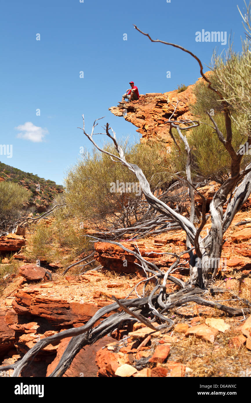 Homme assis sur le bord de la roche, Boucle à pied, le parc national de Kalbarri, Australie occidentale Banque D'Images