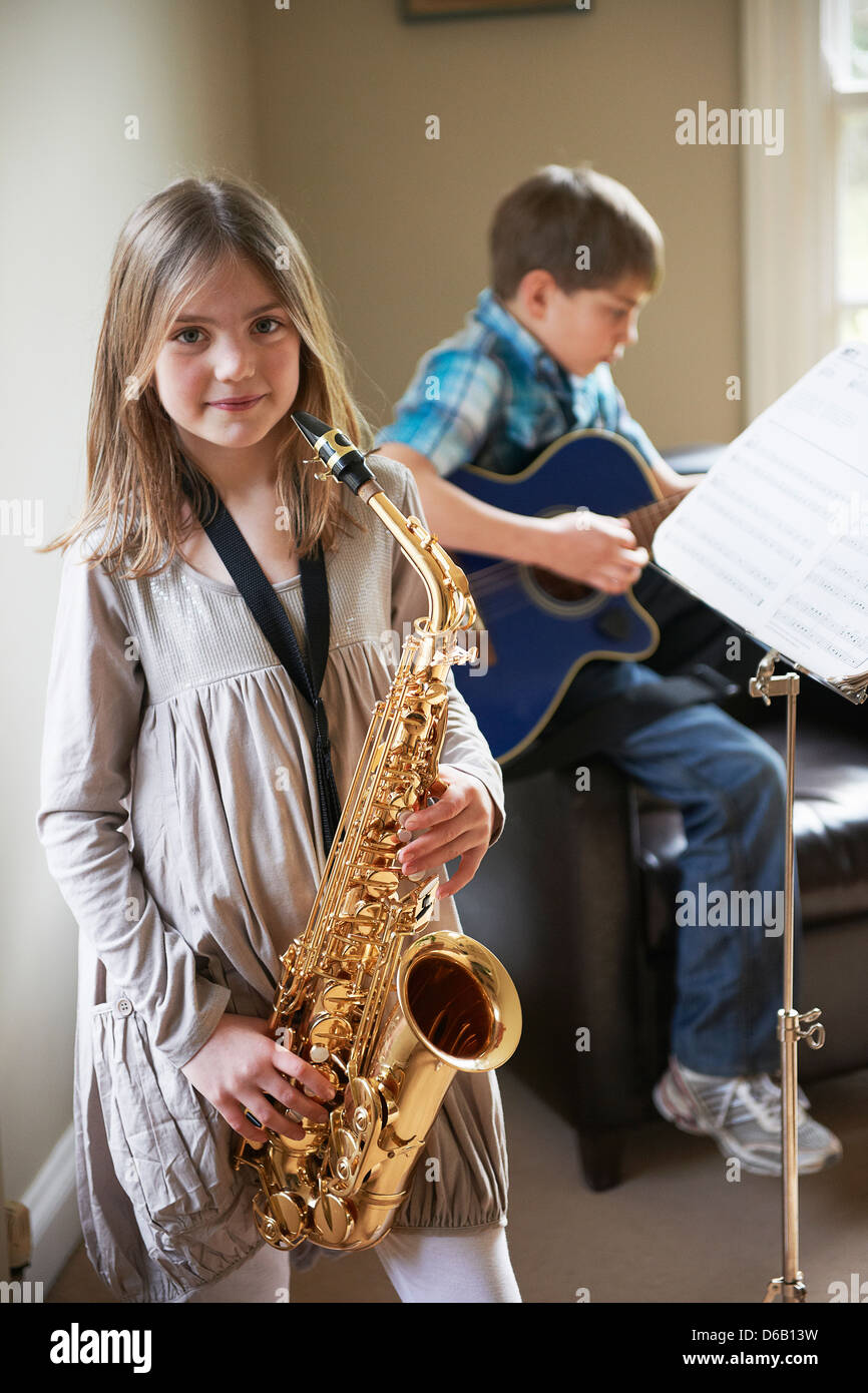 Smiling girl playing saxophone Banque D'Images