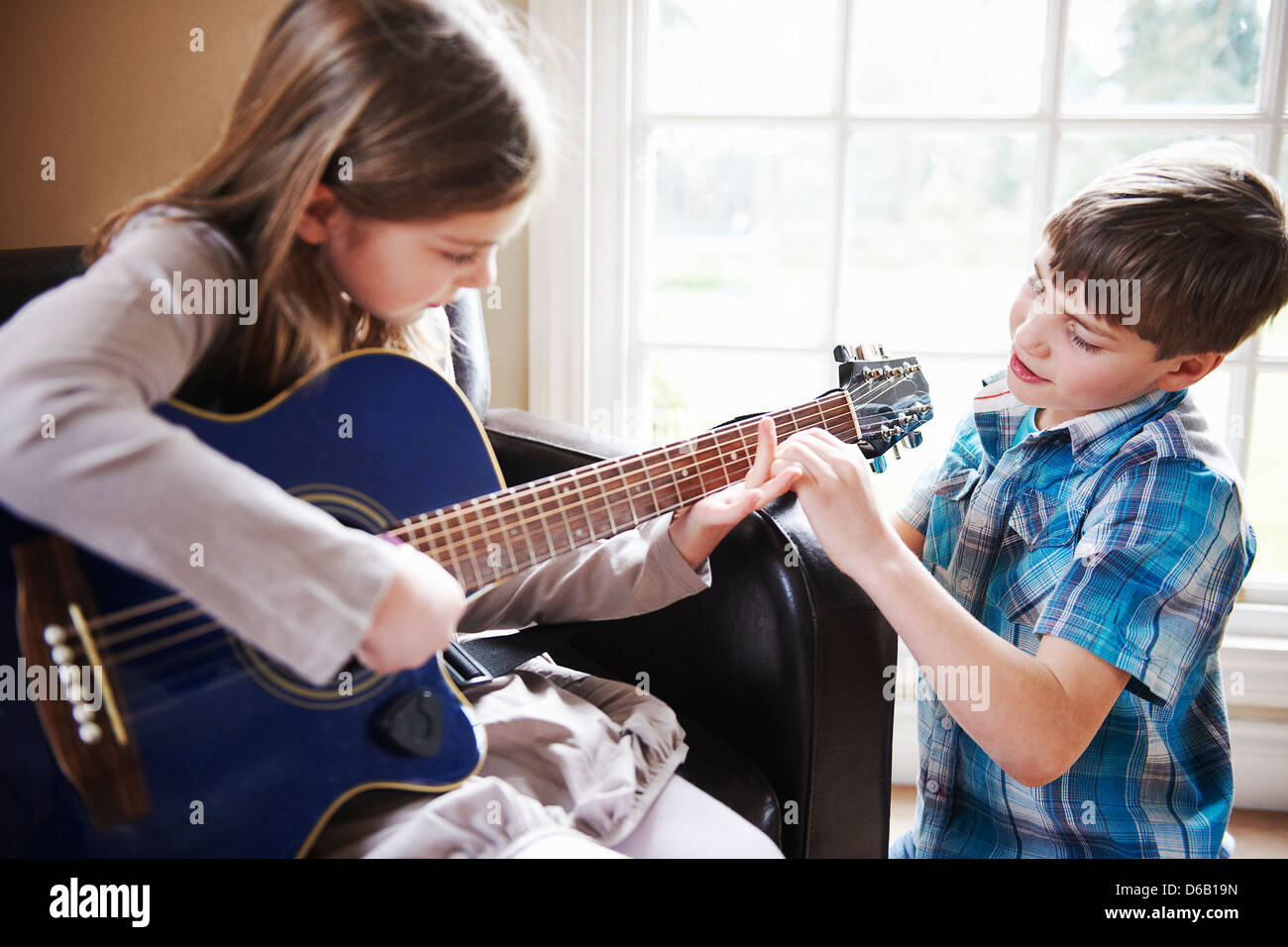 Garçon Fille aidant à jouer de la guitare Banque D'Images