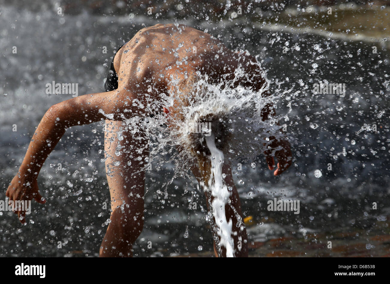 Les gens vous rafraîchir à la fontaine de joie à Rostock, Allemagne, 18 août 2012. Les météorologues prévoient des températures record en Allemagne pour le week-end. Photo : Bernd Wuestneck Banque D'Images