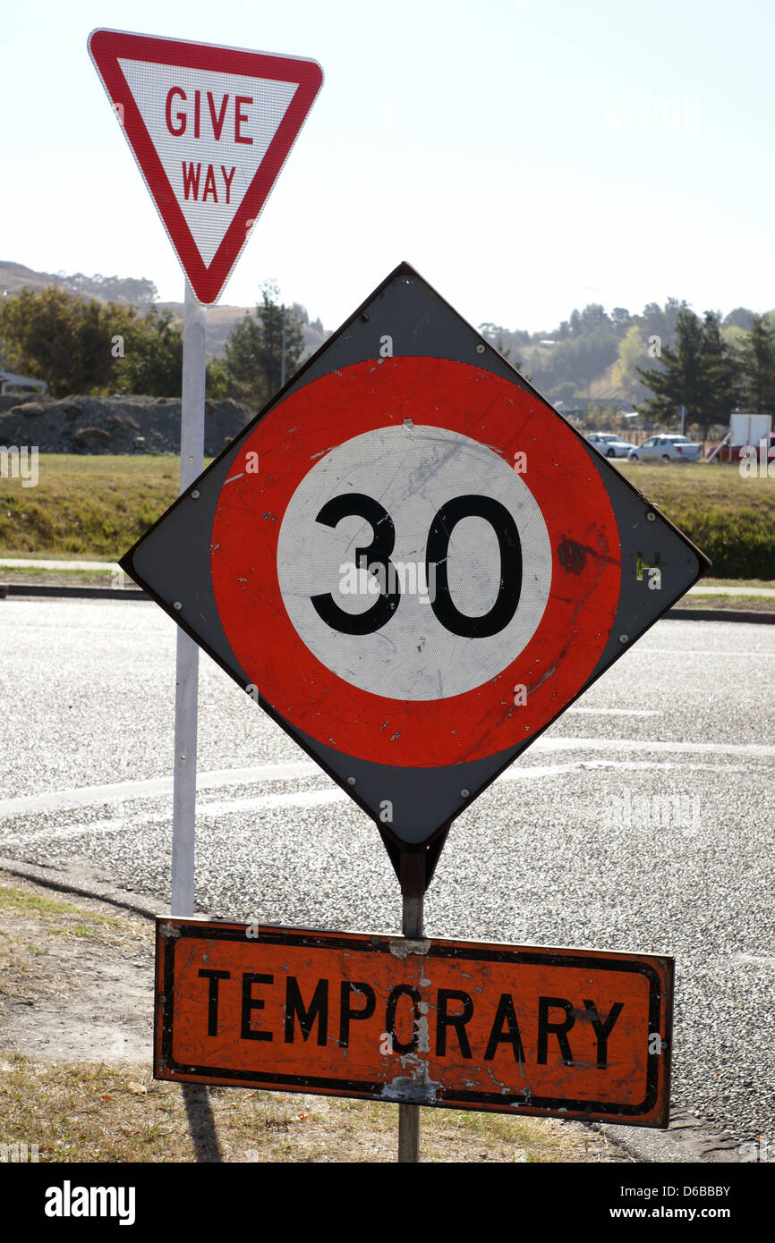 Limite de vitesse temporaire de 30 km/h et faire place à un panneau routier urbain junction en Nouvelle Zélande Banque D'Images