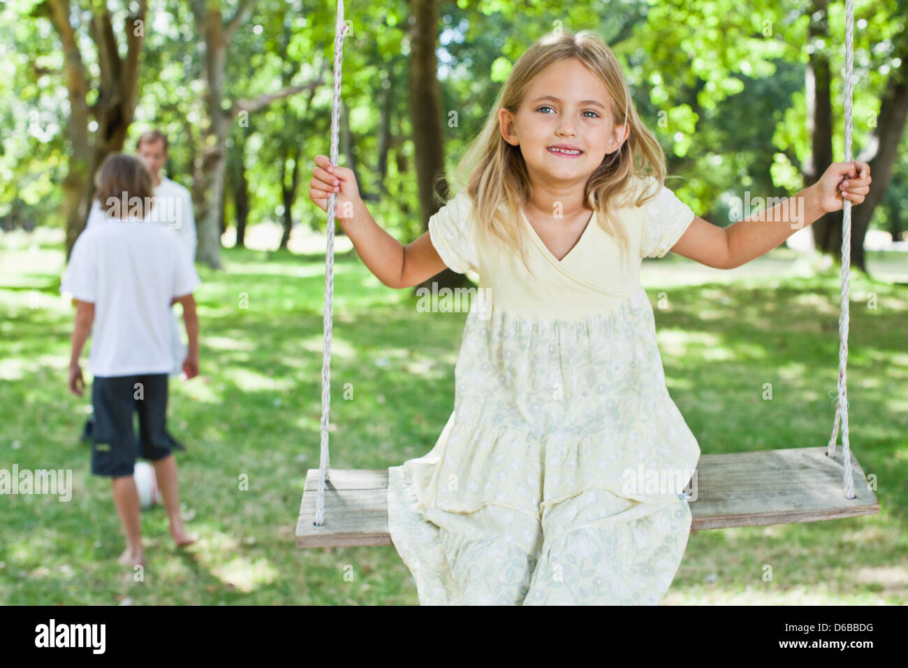 Girl playing on swing in park Banque D'Images