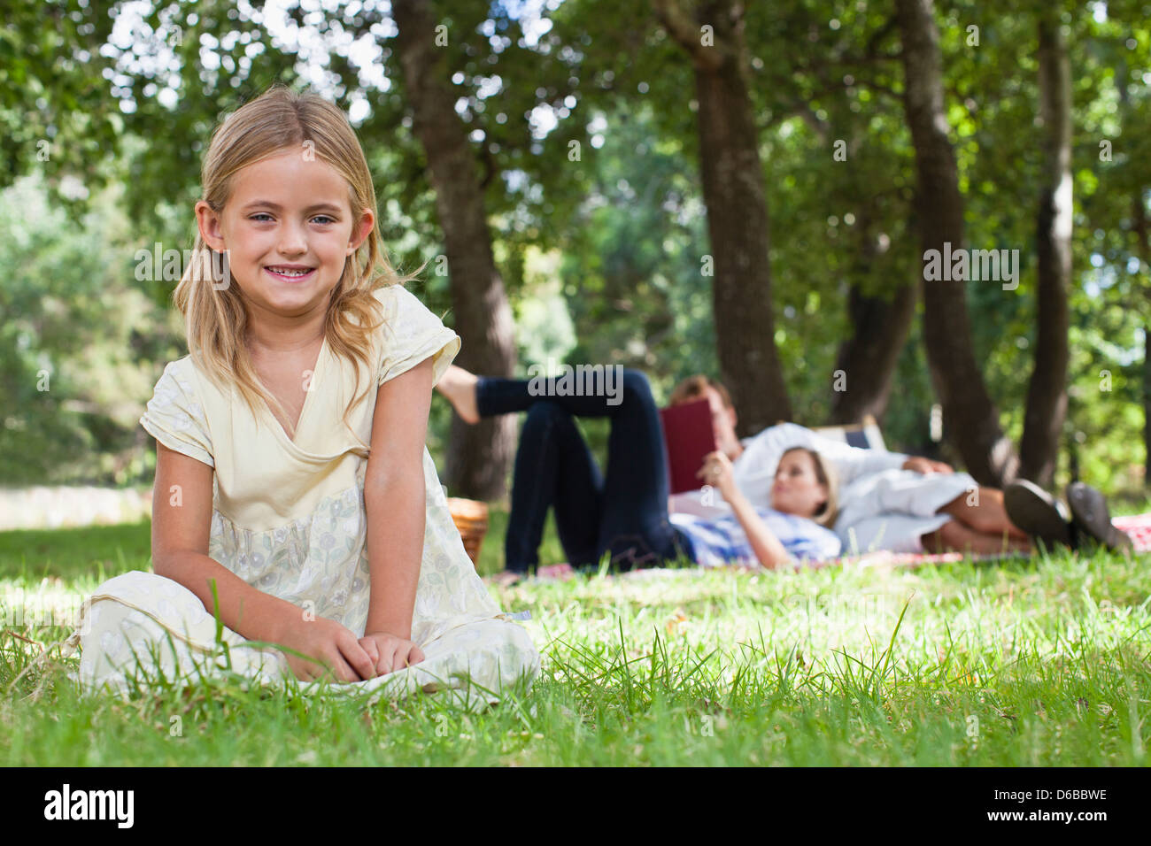 Girl sitting in grass at park Banque D'Images