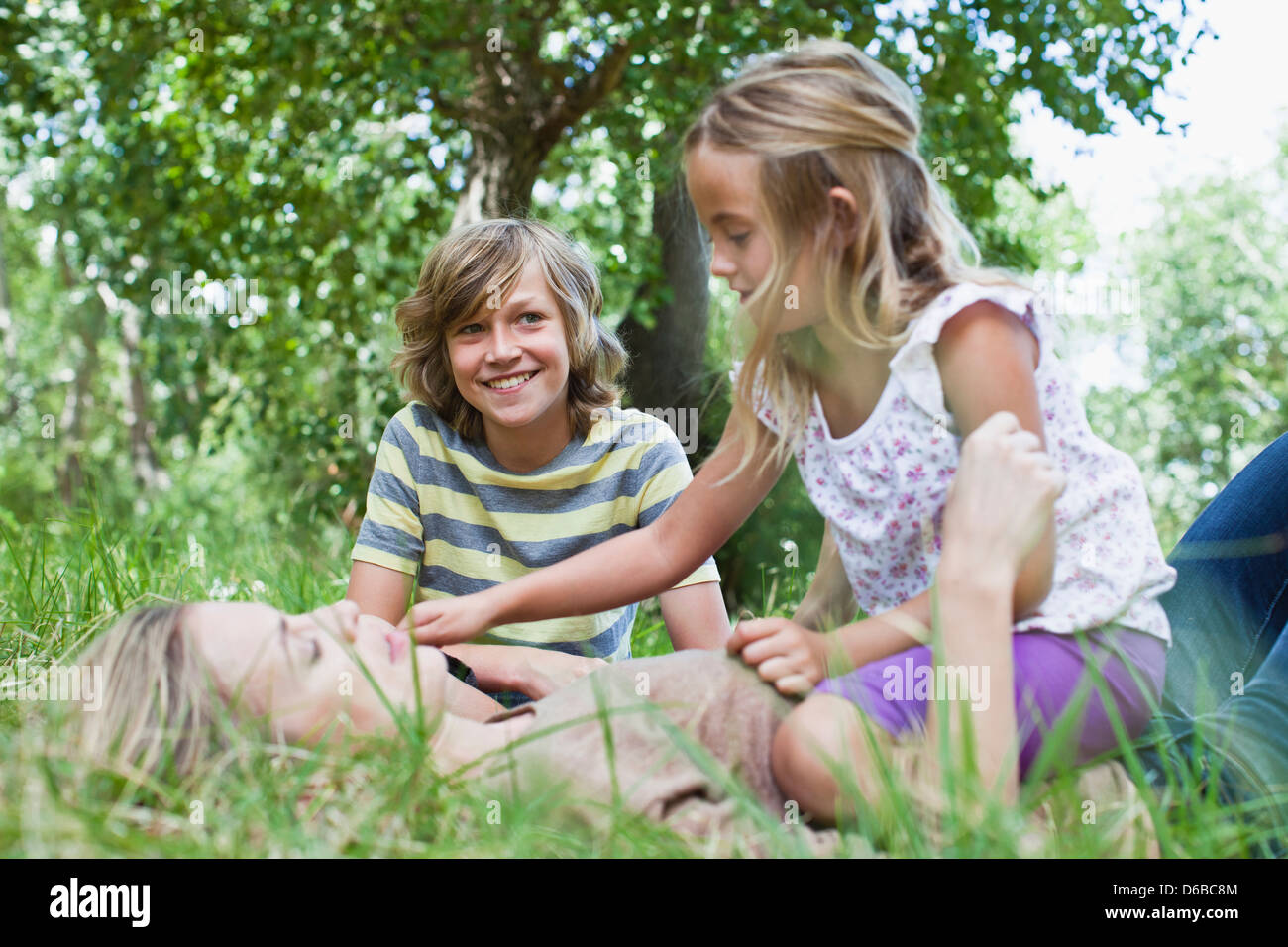Mère et enfants jouant dans le parc Banque D'Images