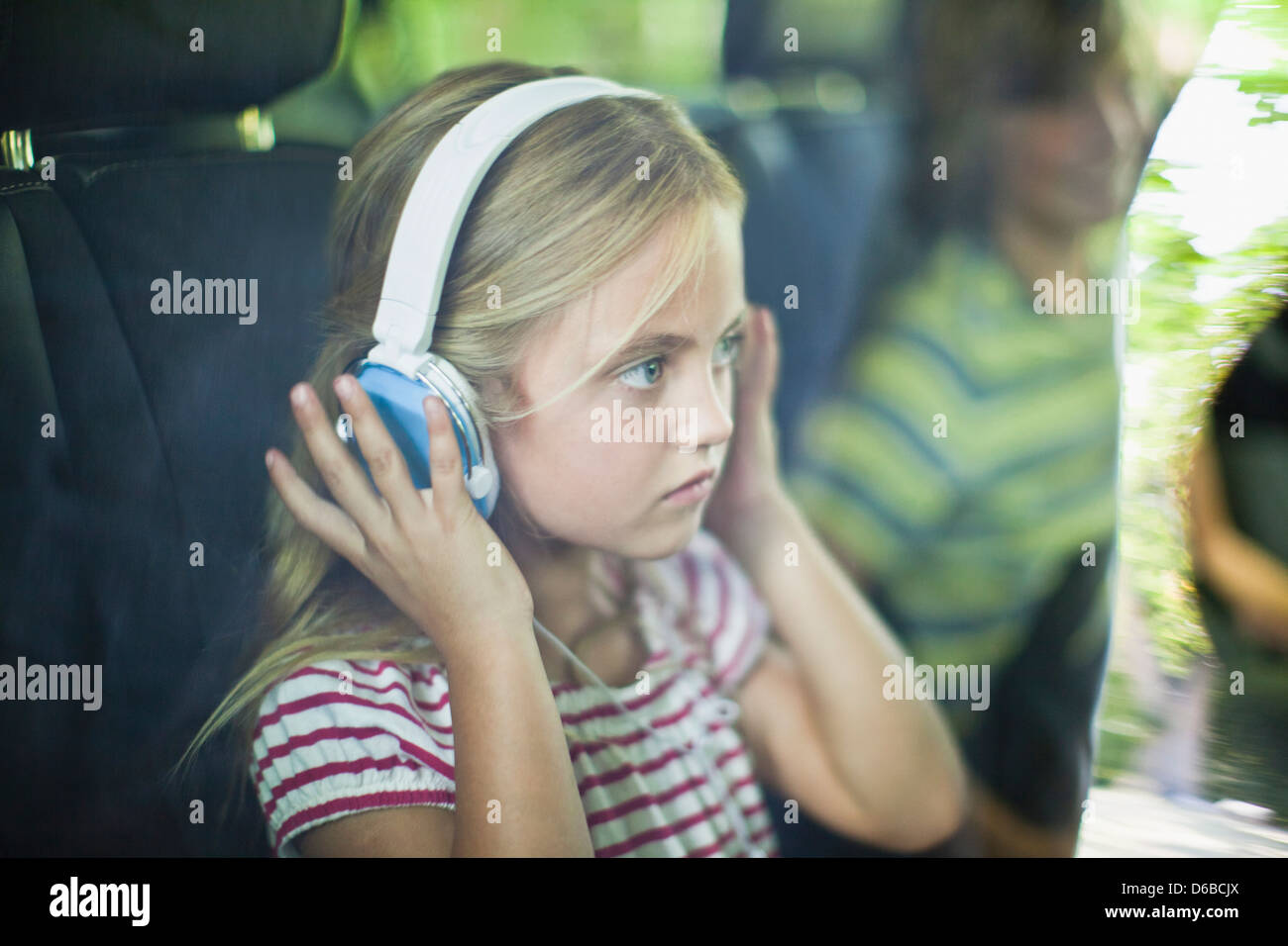 Girl listening to headphones in car Banque D'Images