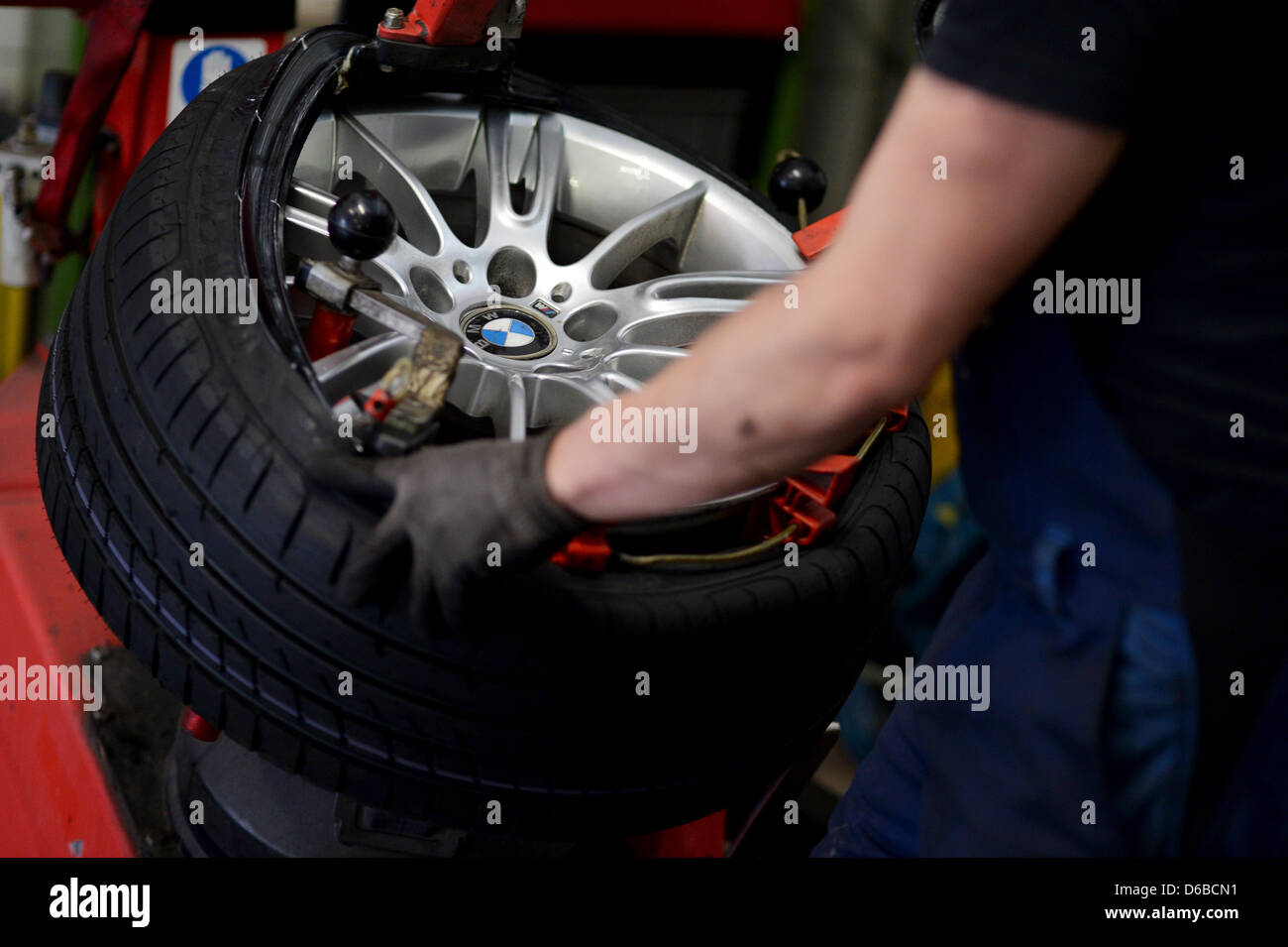 Un mécanicien vis des pneus d'été une BMW dans un atelier à Bayreuth, Allemagne, 16 avril 2013. Les pneus sont en train de changer plus tard cette année en raison de la longueur de l'hiver. Fatigué de l'hiver devrait être supprimé qu'à une température moyenne d'au moins 7 degrés. Photo : DAVID EBENER Banque D'Images